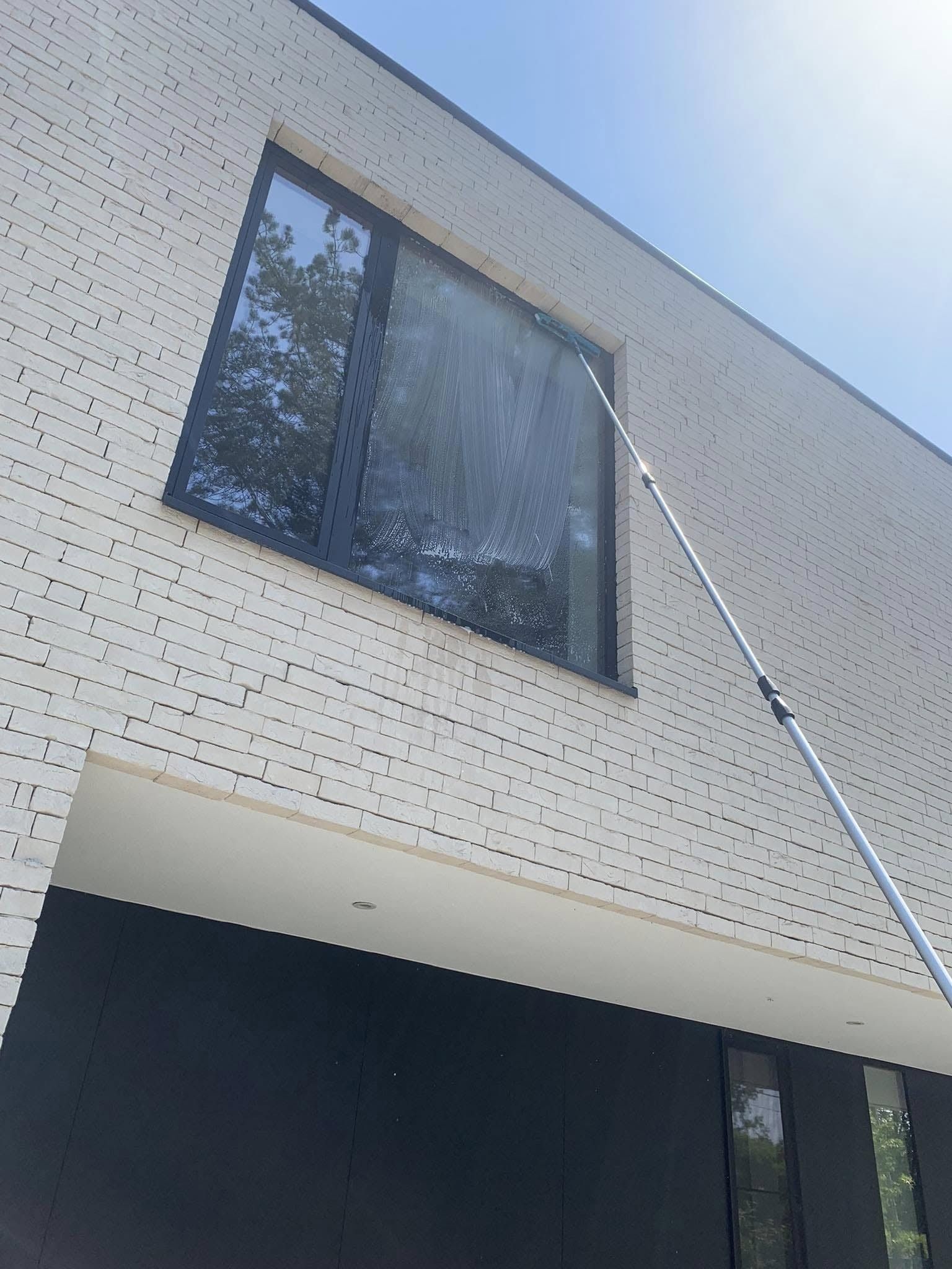 Raam op de verdieping wordt gewassen met een telescoopsteel